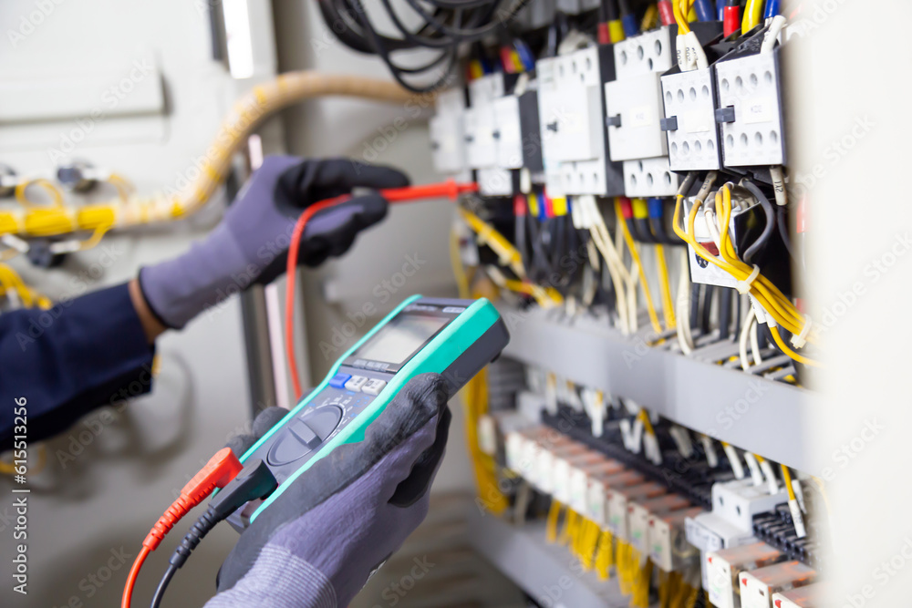 A worker using a tool to test electrical cables