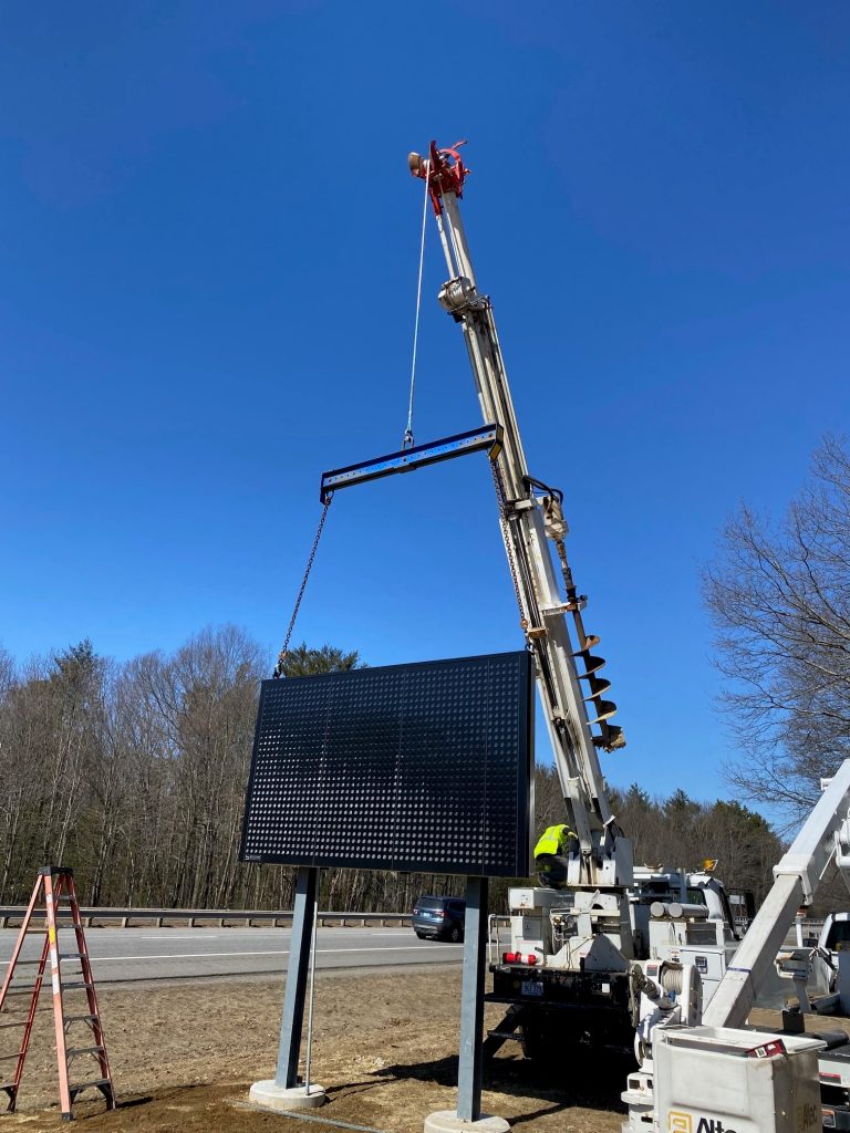 A crew installing a digital highway sign